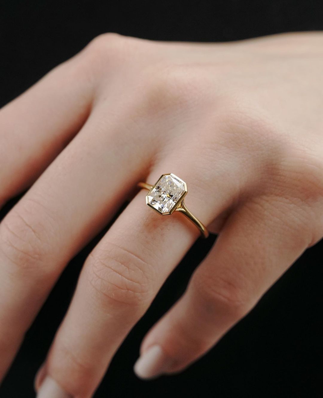 2 CT Emerald Cut Lab Grown Engagement Ring in 18K Gold. A vintage-inspired, uniquely bezel-set promise of minimalist wedding bliss.